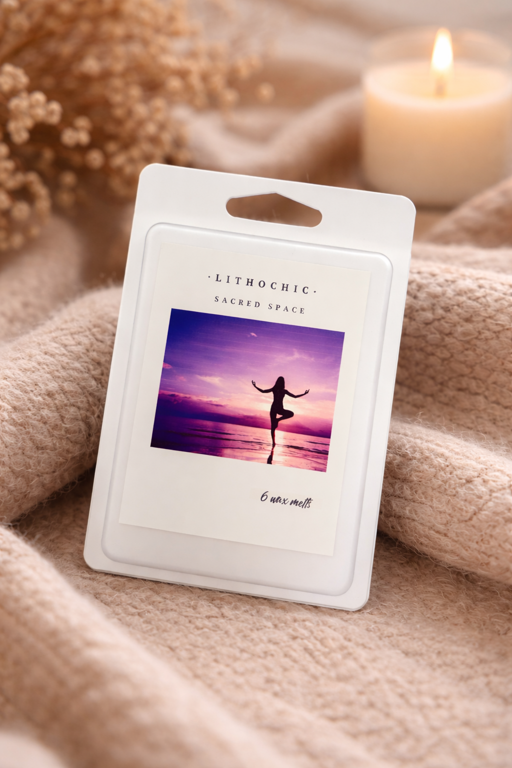 LithoChic product packaging with a woman in a yoga pose on a sunset beach, placed on a soft fabric background.