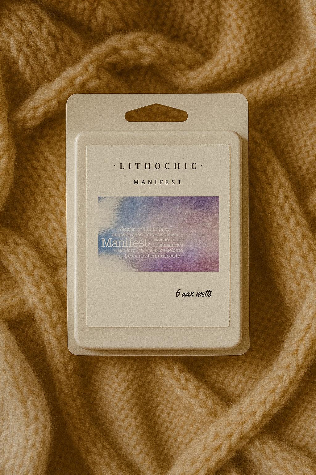 Lithochic Manifest wax melt packaging on a textured brown fabric background